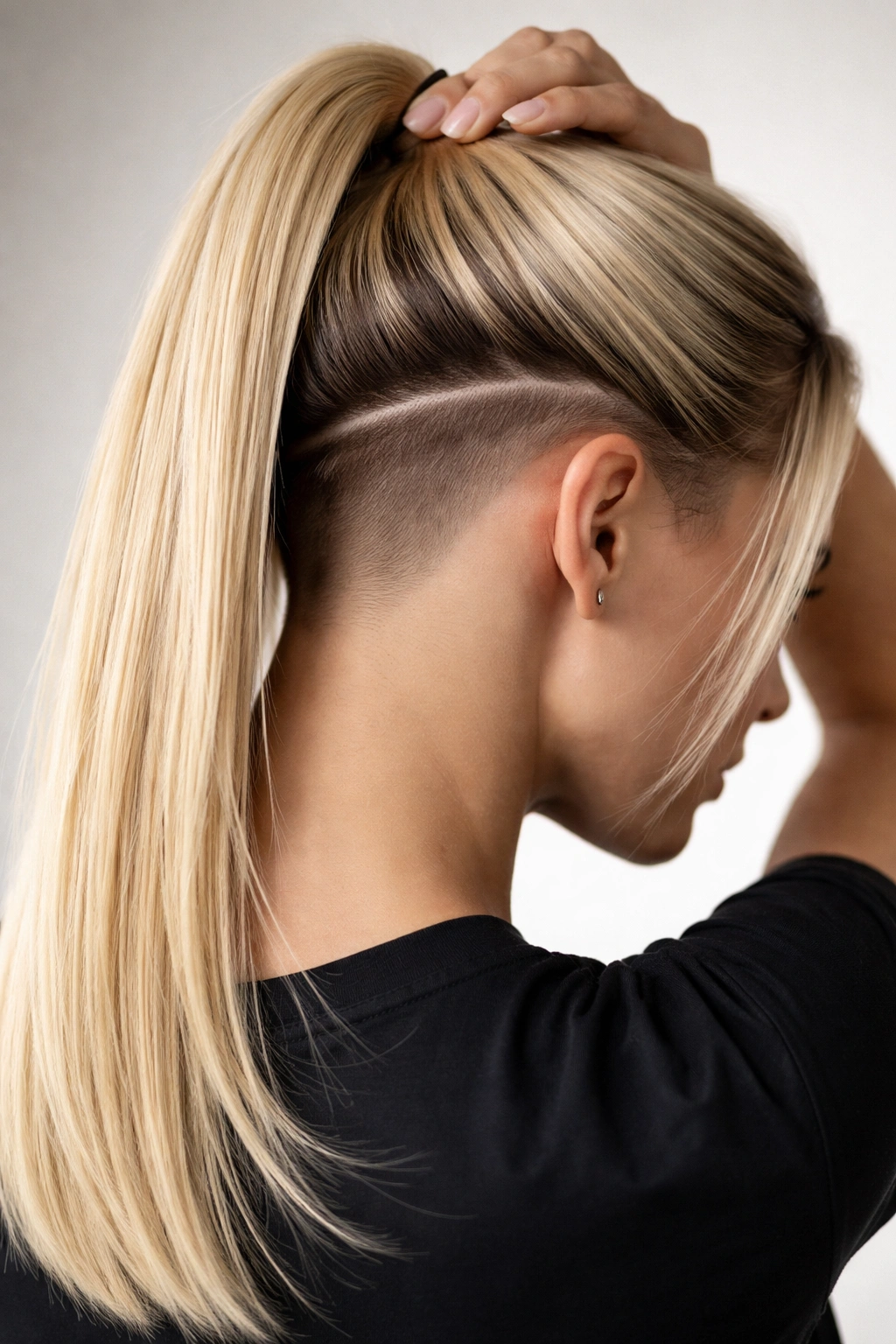 Portrait showing blonde straight hair with razor-sharp undercut visible at the nape