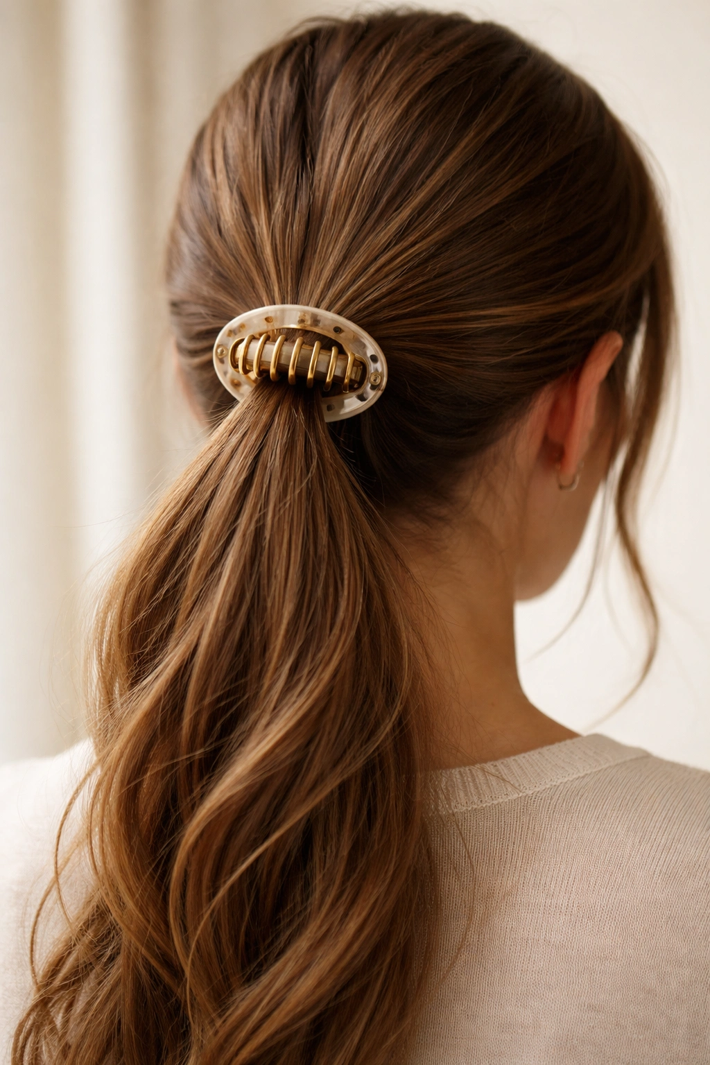 Ponytail secured with a round claw clip at the base
