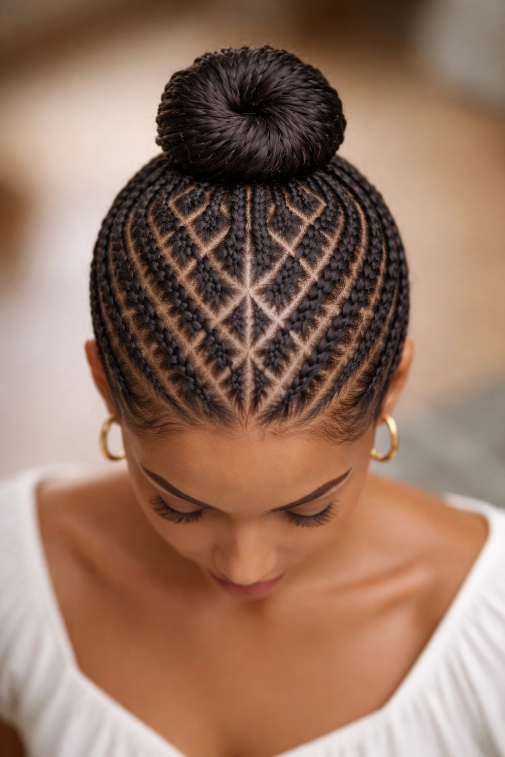 Diamond-pattern cornrows converging at the crown into a center bun
