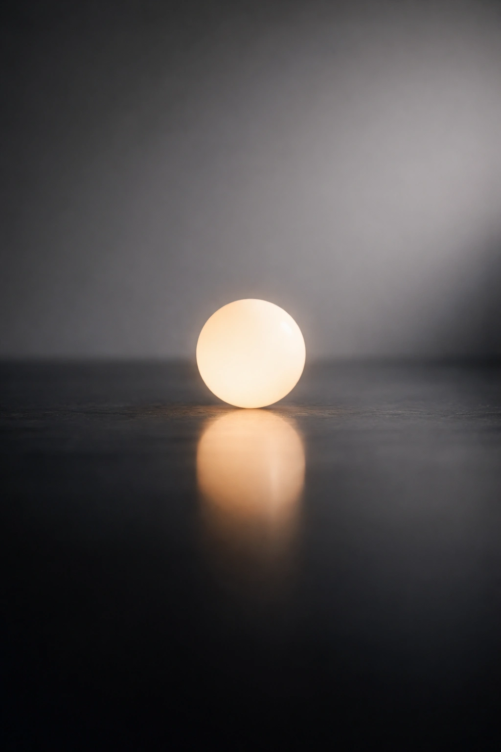 Close-up of a single glowing orb on a reflective surface with a soft gradient background, symbolizing final thoughts
