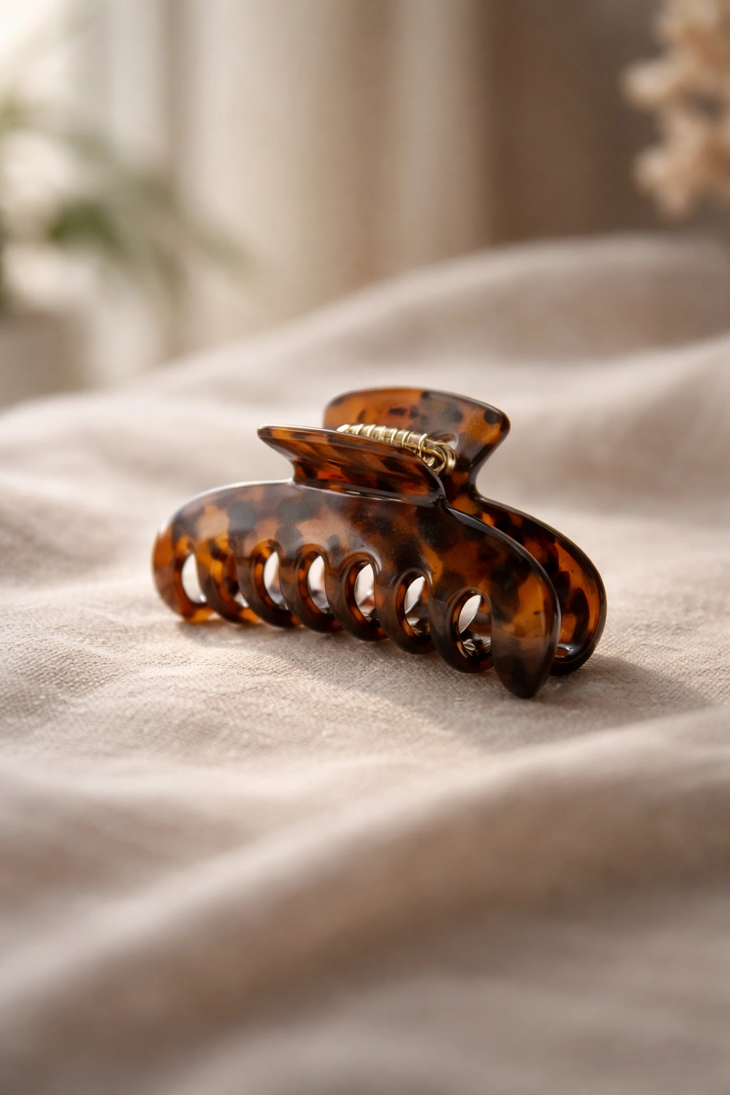Minimal still life of a single claw clip on a neutral surface