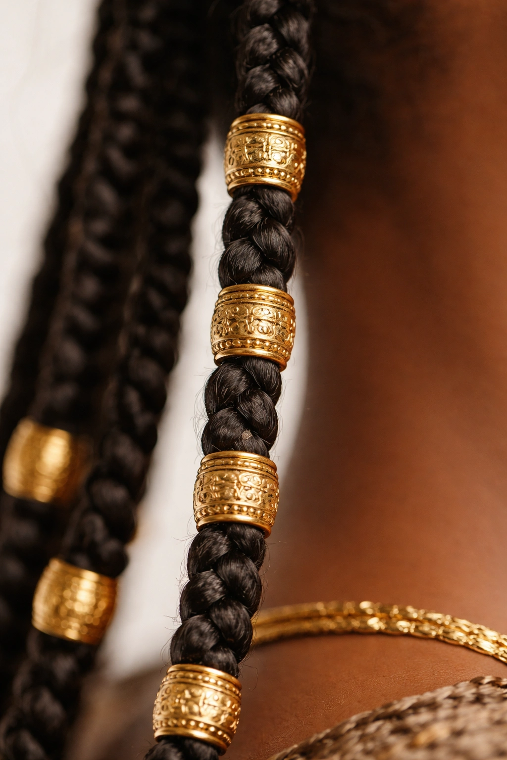 Close-up of a Fulani braid with evenly spaced gold beads along its length