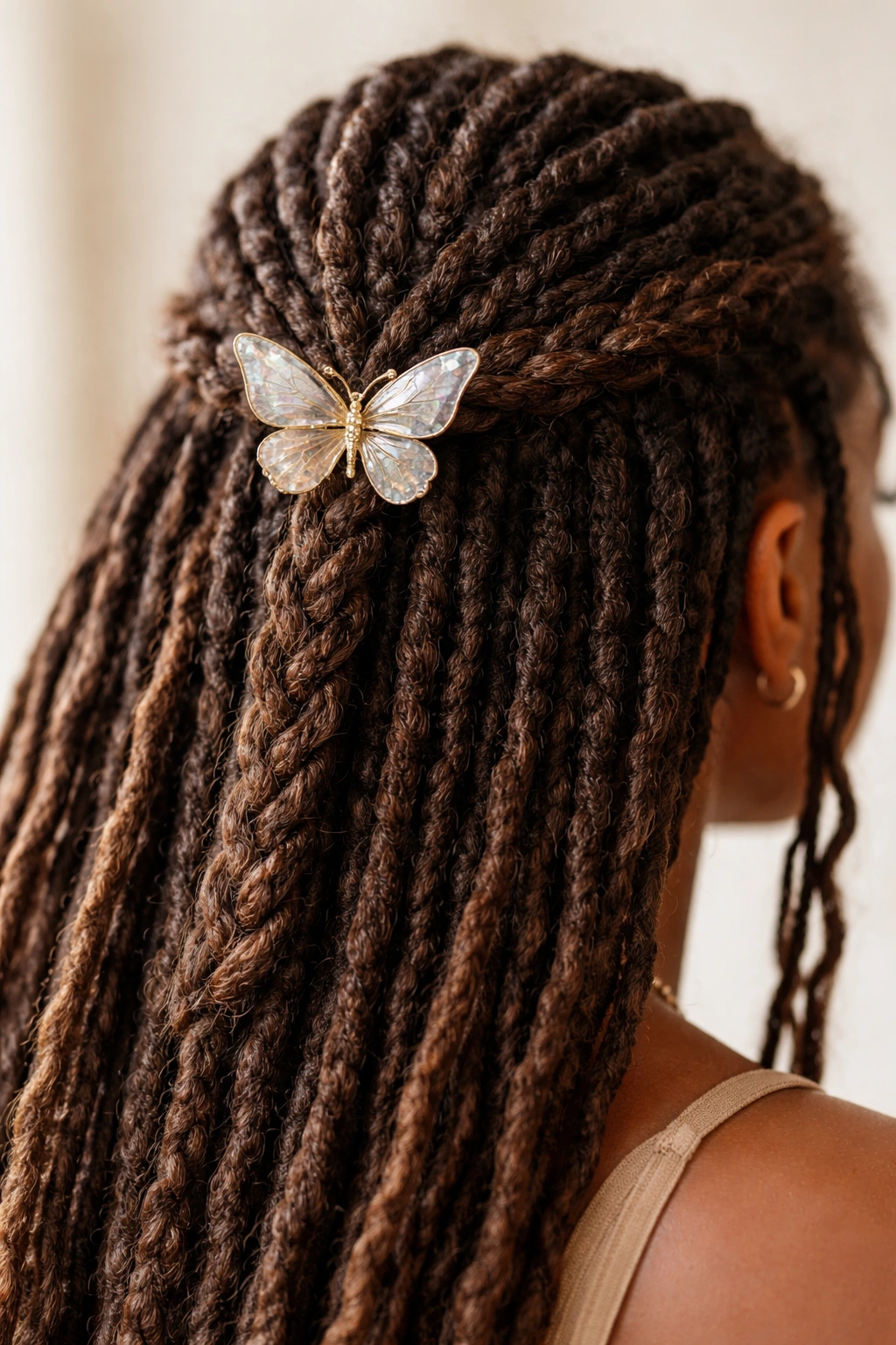 Braided locs in the upper half secured with a butterfly clip