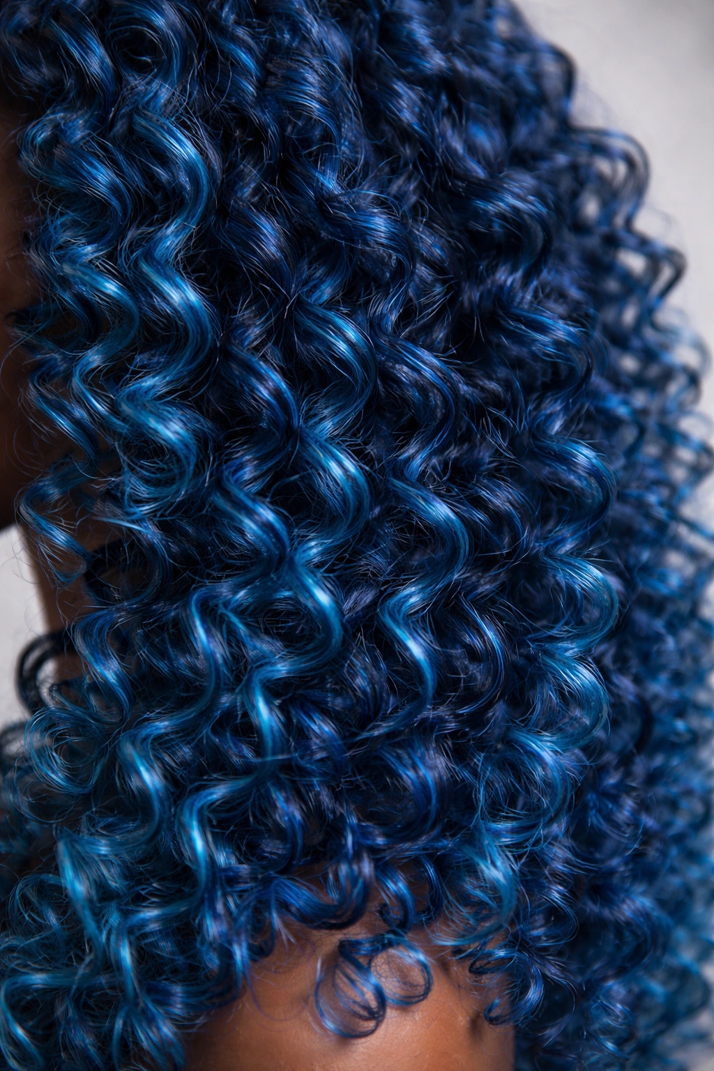 Close-up of ocean blue coily hair with movement in curls