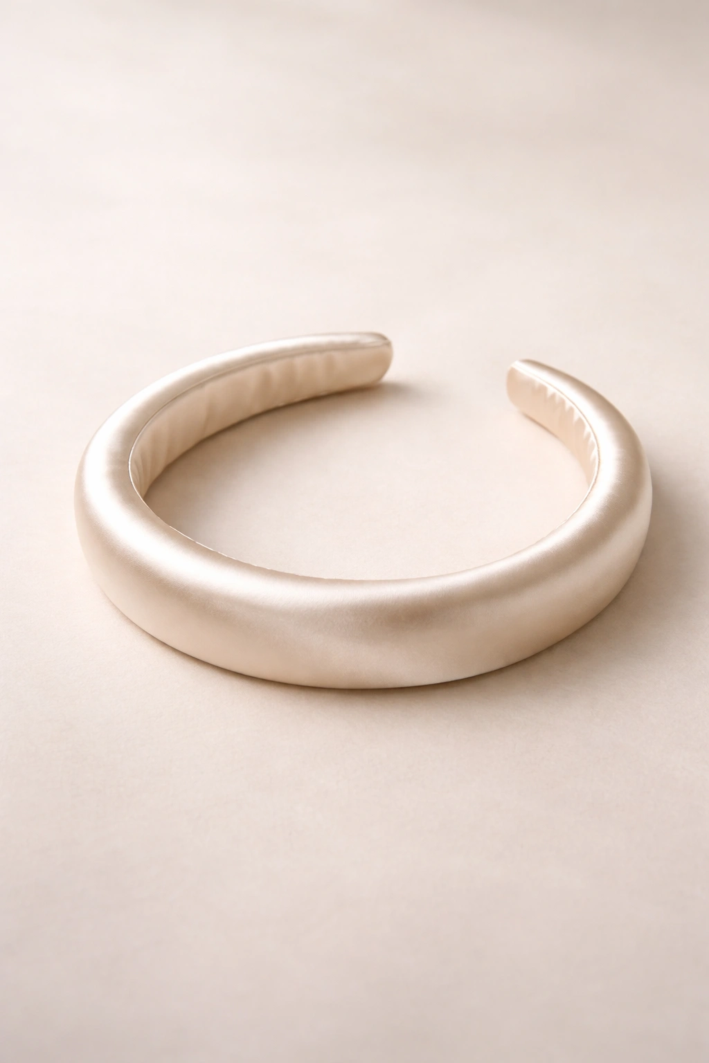 Silk slip headband with glossy satin-like surface on neutral backdrop