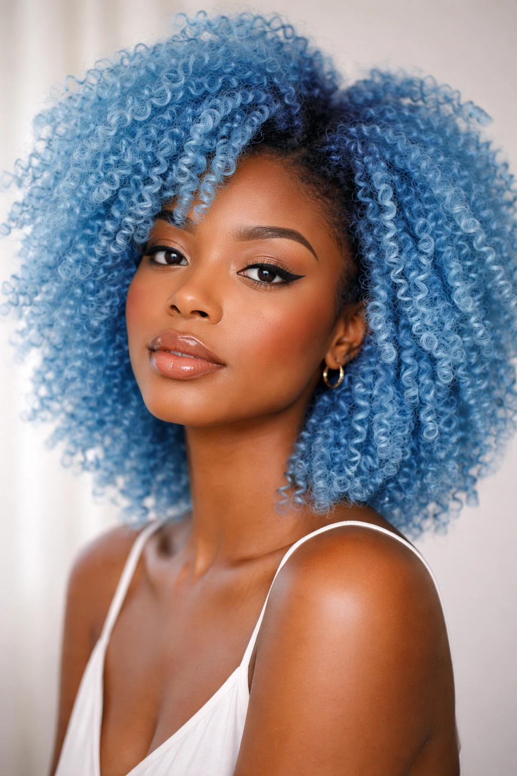 Close-up of sky blue coily hair with gradient and defined curls