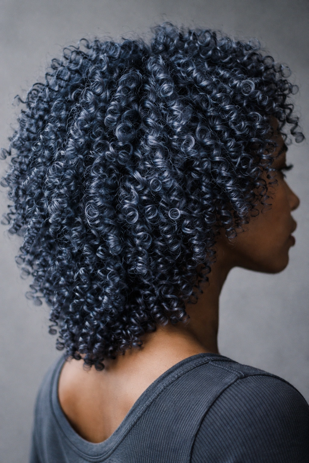 Close-up of slate blue coily hair with gray undertones and textured curls