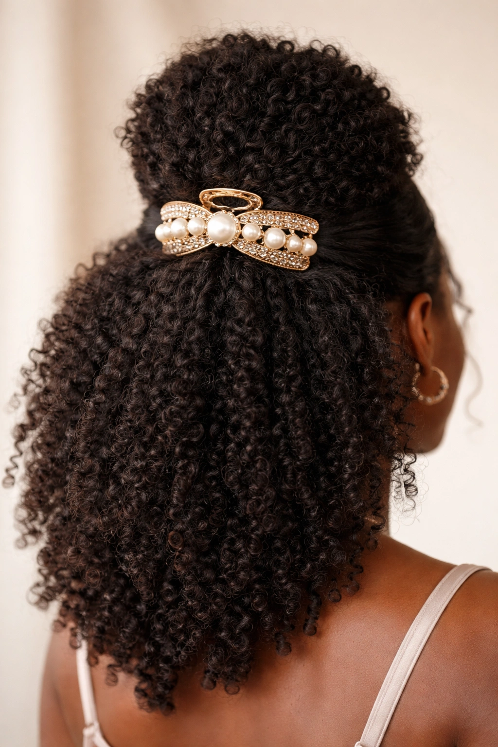 Close-up of a bold oversized claw clip on 4C hair half-up