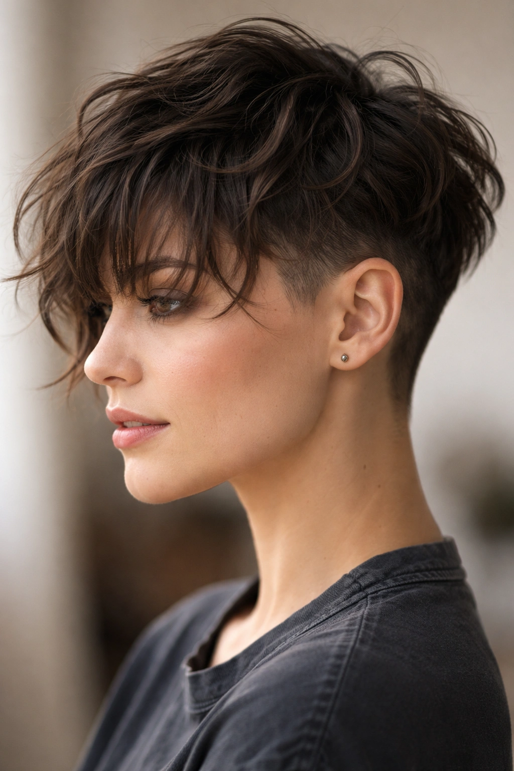 Undercut with wispy bangs showing top texture and shaved sides.