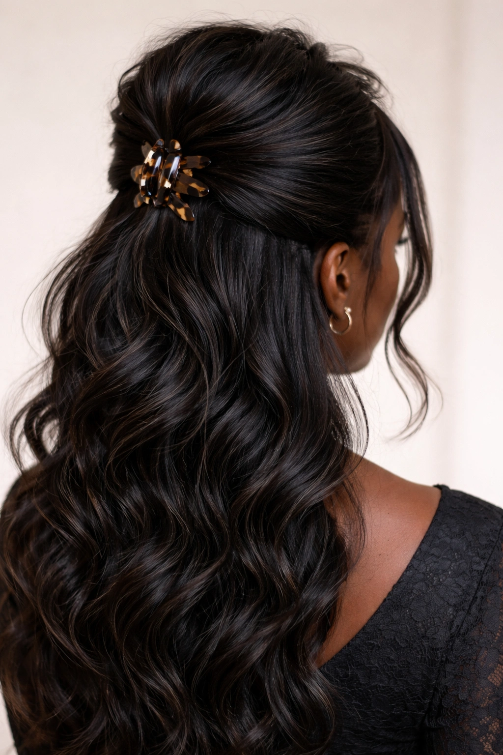 Teased crown volume with claw clip securing a half-up hairstyle on long hair
