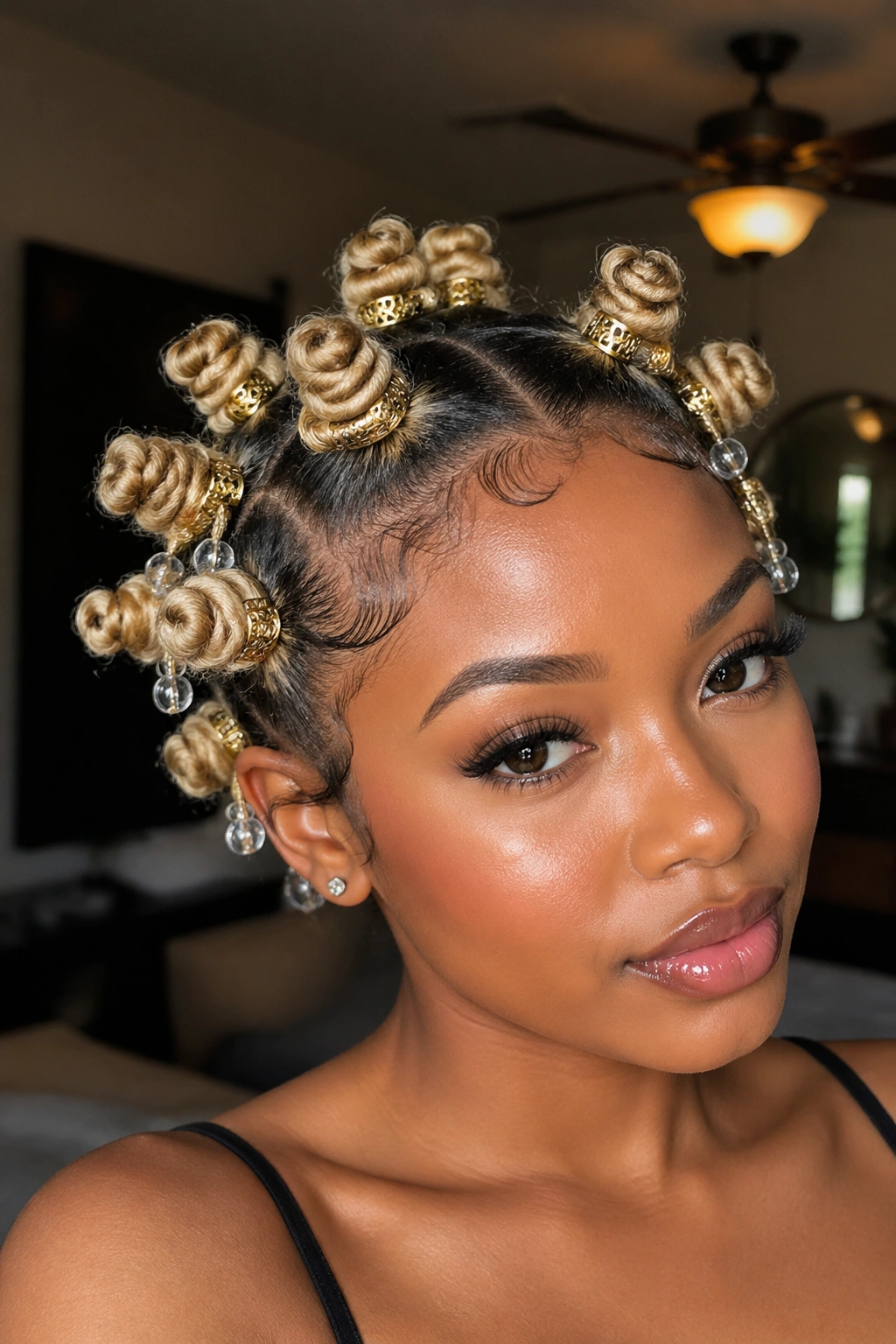 Close-up of a real person with blonde knots adorned with gold cuffs and beads.