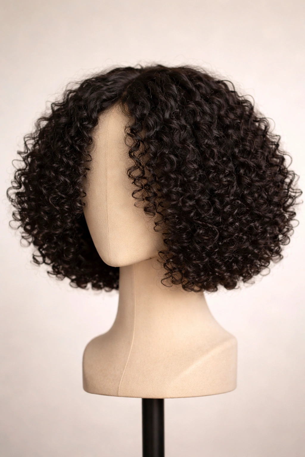 Curly bob wig with blunt ends and matte finish on head form