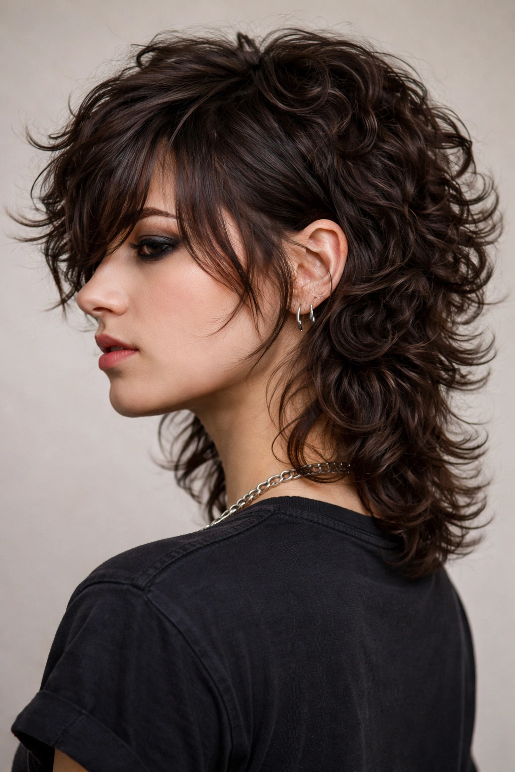 Close-up of curly mullet with flipped nape showing textured crown and backward curl.
