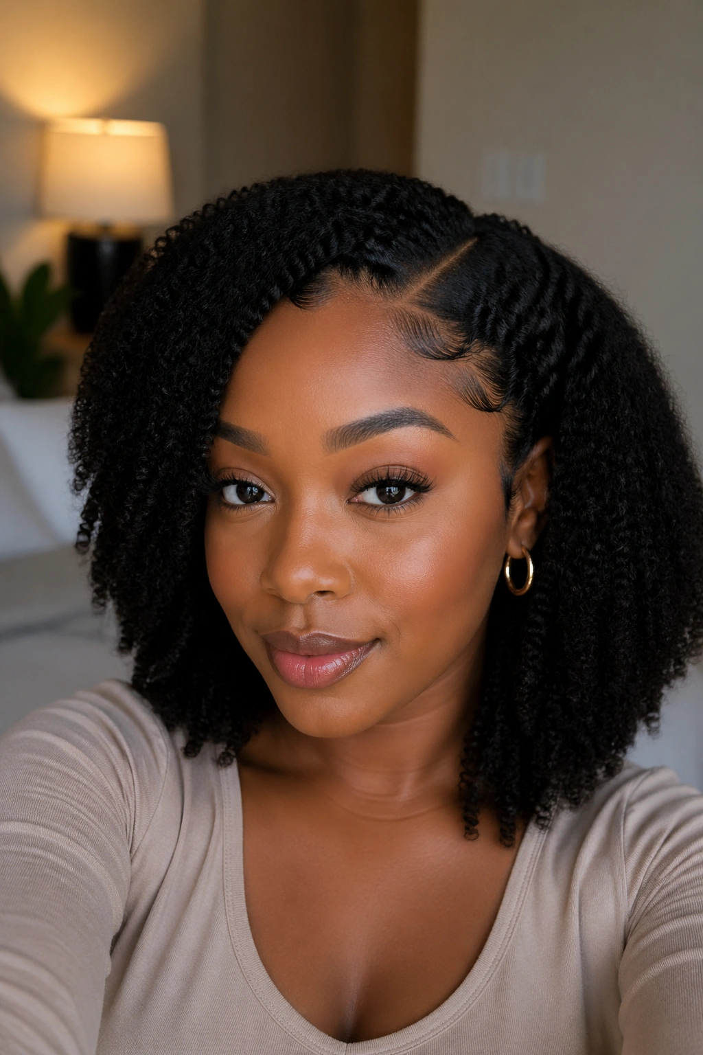 Portrait of a real Black woman wearing a half wig with leave-out blend in a bedroom