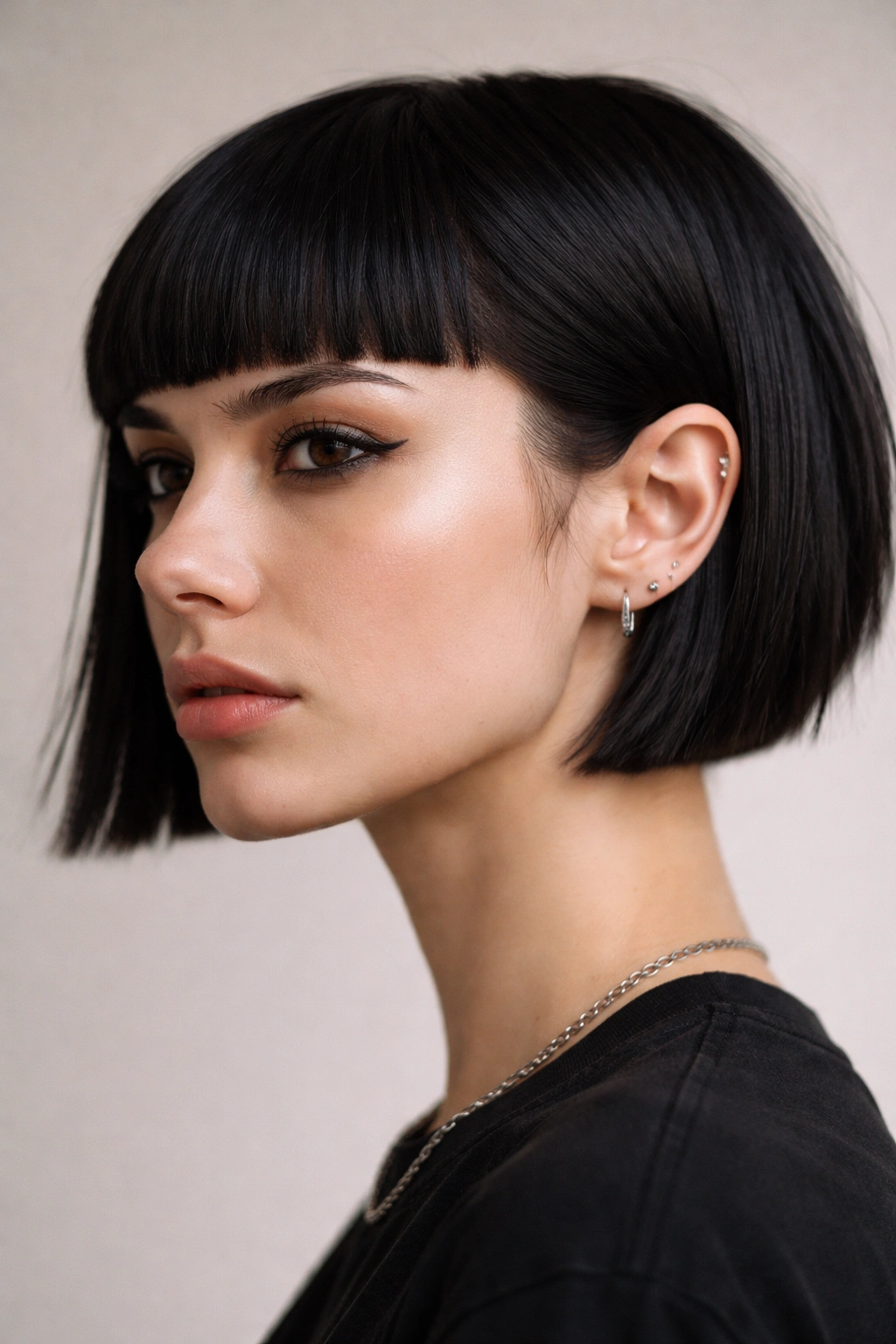 Micro punk bob with blunt fringe: jaw-length silhouette with dense blunt fringe above lashes, crisp edge