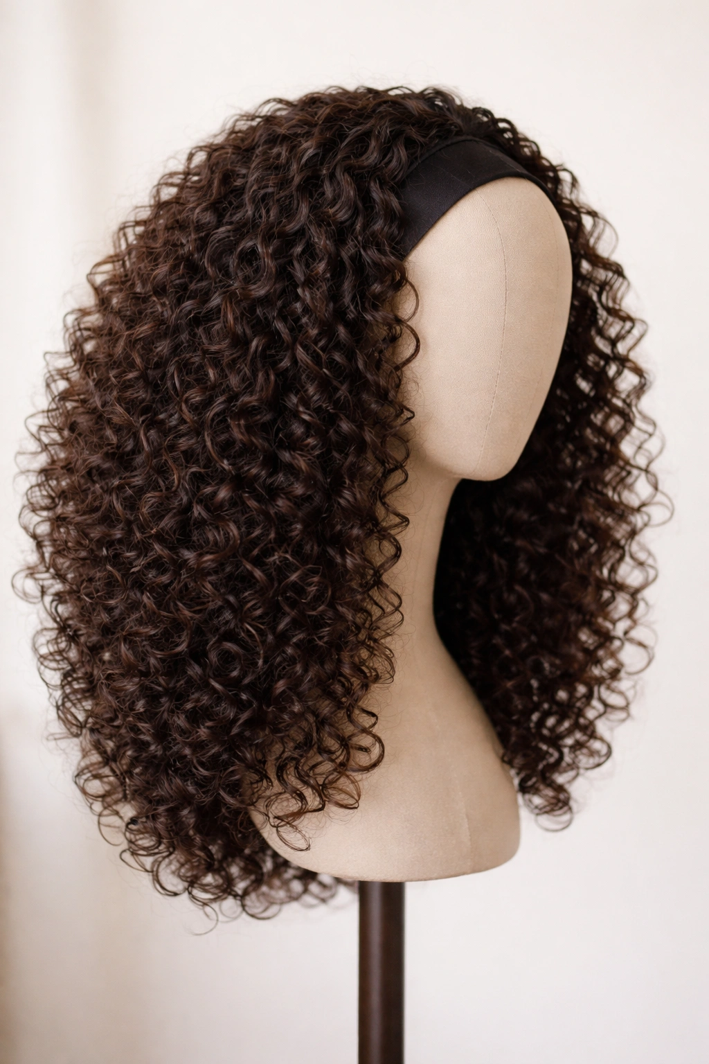 Rounded everyday half-wig with soft layers on a mannequin head, showing a natural rounded silhouette