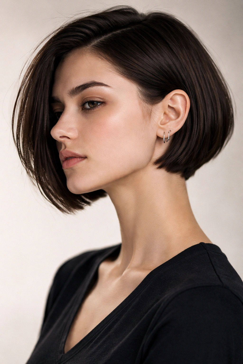 Model with a side-parted tucked bob showing the jawline