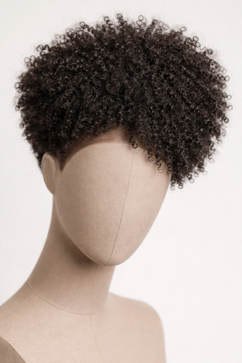 Close-up of tapered coily Afro wig on a headform with tapered sides and fuller crown, matte texture