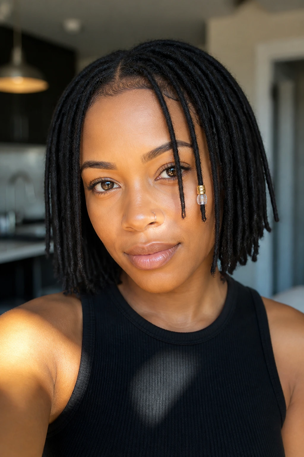 Close-up of a real person with a loc bob featuring a small cluster of beads on the front side