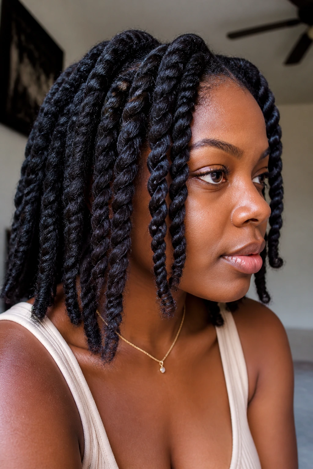 Real woman with chunky twists close-up in a home setting.