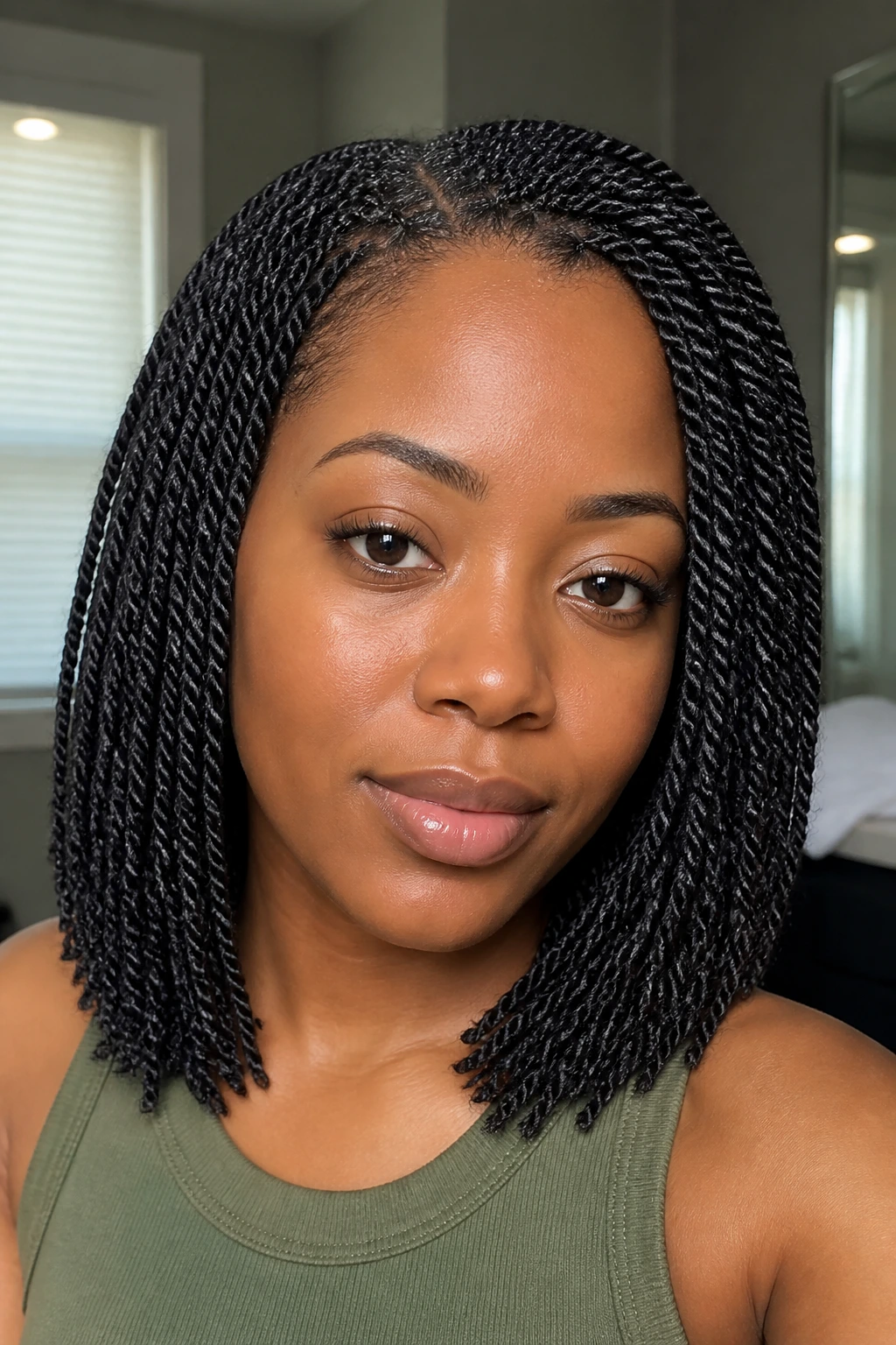 Real woman with mini twists close-up in a home setting.