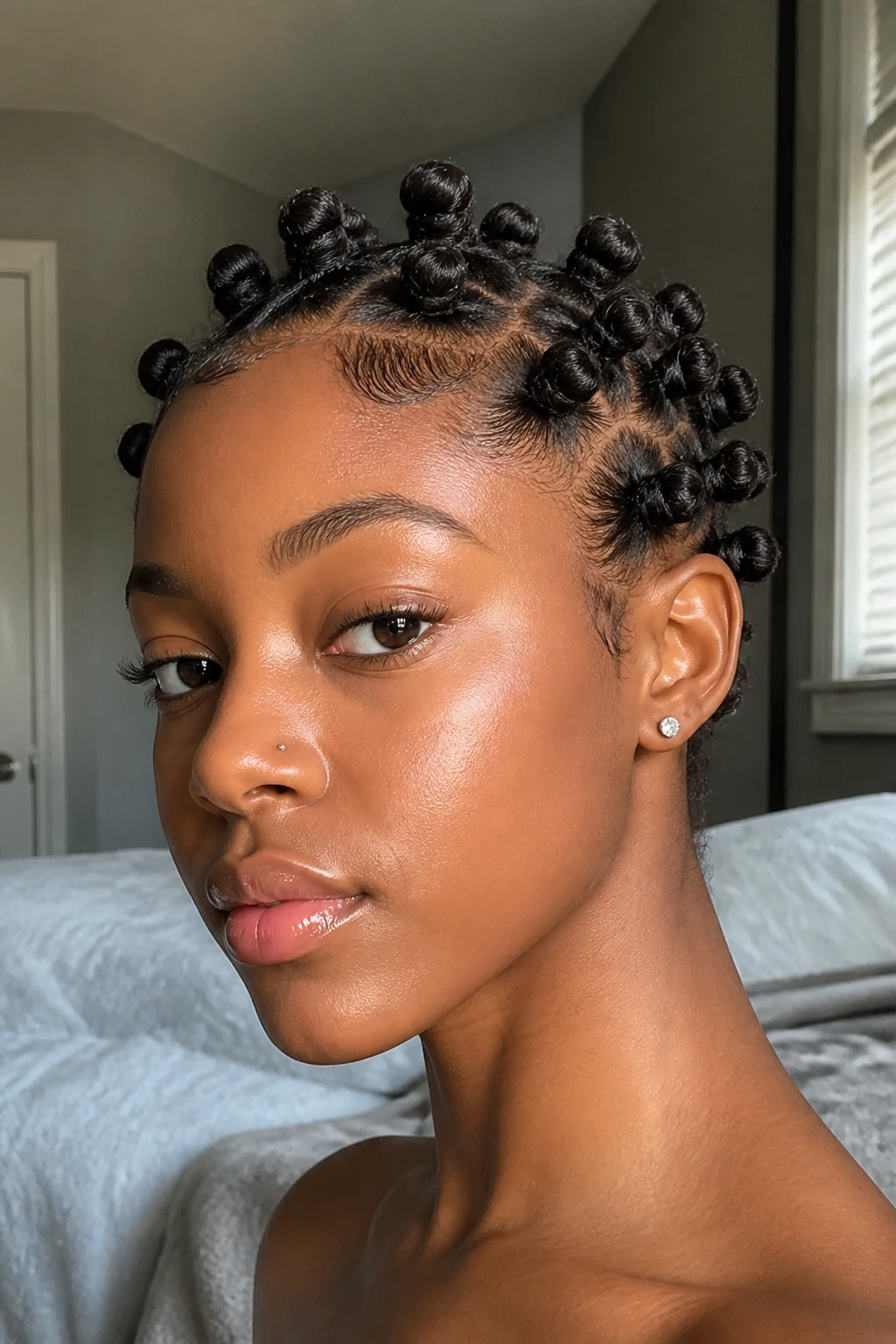 Close-up of a real woman with short pixie Bantu knots around the crown.